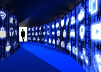 تصویری از یک هکر با کلاه سیاه در کت و شلوار در حال ورود به راهرویی که دیوارهای آن با آیکون‌های آبی رنگ اینترنت اشیا و تصویر سه بعدی مفهوم امنیت سایبری است.